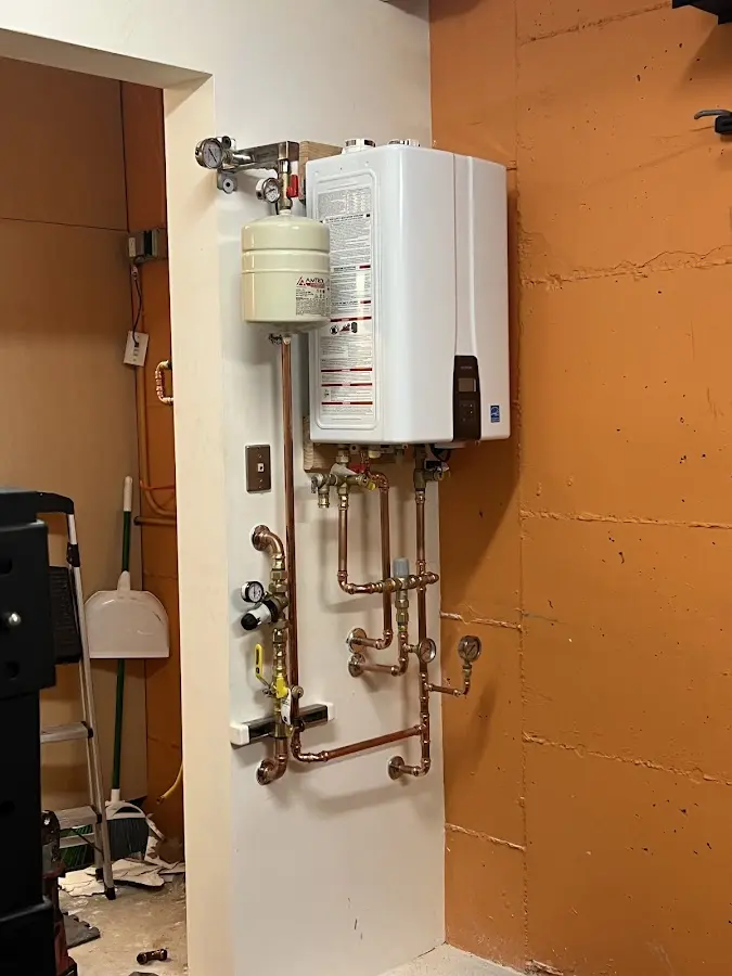 Plumbing technician inspecting water heater connections in East Bridgewater